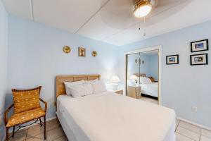 um quarto com uma cama, uma cadeira e um espelho em Continental 201 em South Padre Island