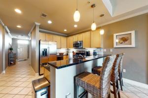 a kitchen with a counter and bar stools at The Wharf 805 in Orange Beach