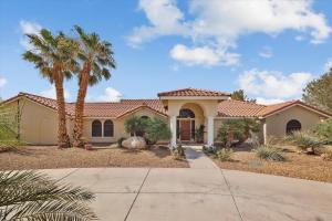 a house with palm trees in front of it at Ranch style villa with pool and spa in Las Vegas
