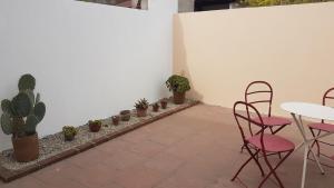 Un patio con mesa y sillas y plantas en macetas. en Dúplex con garage, patio y parrilla, en Tandil