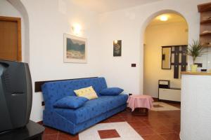 a living room with a blue couch and a tv at Apartments with parking space Pag - 6535 in Pag