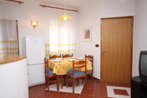 a kitchen with a table and chairs and a refrigerator at Apartments with parking space Pag - 6535 in Pag