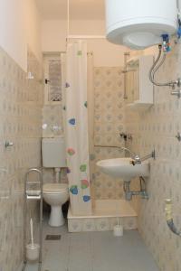 een badkamer met een toilet en een douchegordijn bij Family friendly seaside apartments Vlasici, Pag - 4319 in Vlašići