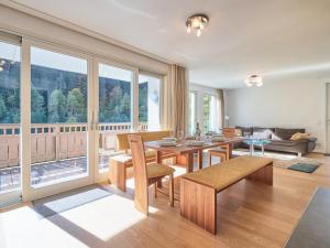 a living room with a table and chairs and a large window at Drei Berge Top 5 in Saalbach Hinterglemm