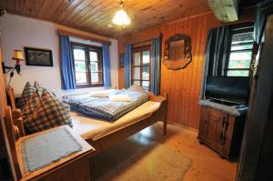 1 dormitorio con 1 cama y TV en una habitación en Haus am Bach, en Bad Kleinkirchheim