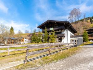 a house with a wooden fence next to a road at Chalet Heimelig M in Saalbach-Hinterglemm