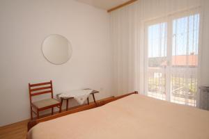 ein Schlafzimmer mit einem Bett, einem Stuhl und einem Fenster in der Unterkunft Apartment Pula 7647a in Pula