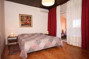 sypialnia z łóżkiem i czerwonymi zasłonami w obiekcie Apartments with a parking space Medulin - 7619 w Medulinie