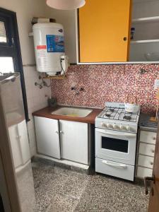 una pequeña cocina con fogones y fregadero en av. Colón Apartamento en Mar del Plata