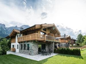 a large house with a deck on a lawn at Chalet Anna XL Leogang in Leogang