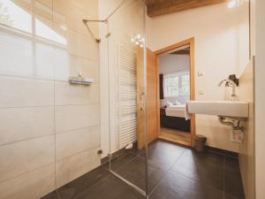 a bathroom with a sink and a glass shower at Chalet Anna XL Leogang in Leogang