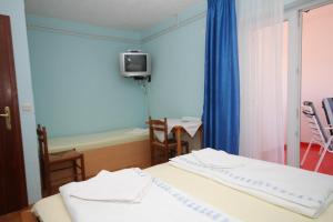 Pokój z dwoma łóżkami i telewizorem na ścianie w obiekcie Triple Room Peroj 2235a w mieście Peroj