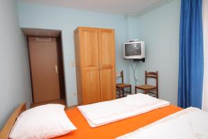 een slaapkamer met een bed en een tv. bij Double Room Peroj 2235d in Peroj