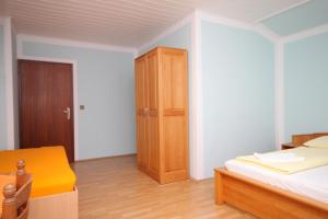 een slaapkamer met een bed en een houten kast bij Triple Room Peroj 2235f in Peroj