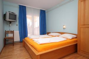 a bedroom with a bed and a tv and a window at Rooms with a swimming pool Peroj, Fazana - 2235 in Peroj