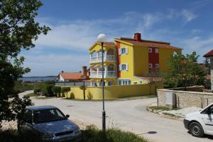 a yellow building with a car parked in front of it at Double Room Peroj 2235h in Peroj