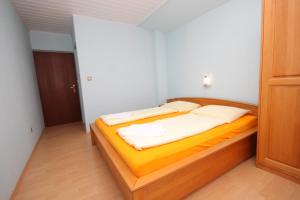 a bedroom with a bed with yellow sheets and white pillows at Double Room Peroj 2235h in Peroj