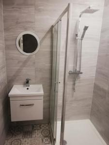 a bathroom with a shower and a sink and a mirror at Moorburn Heights in Largs