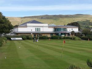 a golf course with a building in the background at Moorburn Heights in Largs