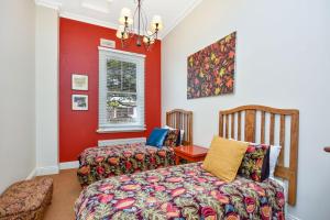 a bedroom with two beds and a red wall at Coolangatta in Katoomba