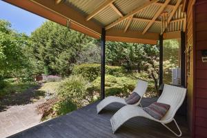 2 sillas blancas en un porche con techo en Coolangatta en Katoomba