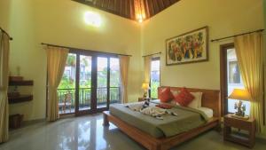 una camera da letto con un letto in una stanza con finestre di The Suci Sari Ubud ad Ubud Altre 37 foto