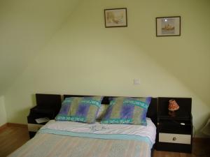 a bedroom with a bed with two pillows on it at Ancien corps de ferme restauré avec jardin clos, proche A11, 3 chambres, barbecue, calme garanti - FR-1-410-343 in Le Bailleul