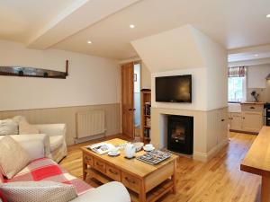 a living room with a couch and a fireplace at Sawmill Cottage in Royal Tunbridge Wells