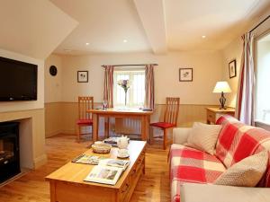 a living room with a couch and a table at Sawmill Cottage in Royal Tunbridge Wells
