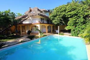 a large house with a swimming pool in front of it at Surfbreak B&B in Cabarete