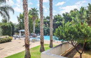 eine Gruppe von Palmen neben einem Pool in der Unterkunft Gorgeous Home In Marina Di Ragusa in Marina di Ragusa