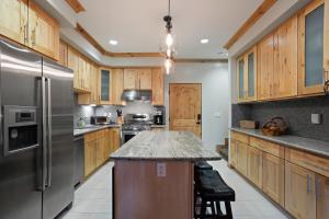 a kitchen with wooden cabinets and a stainless steel refrigerator at Modern Condo - EV Plug In - SM 301 in Bear Valley