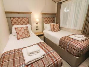 duas camas num quarto de hotel com toalhas em Coniston View 9 em Carnforth