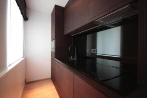 cocina con armarios negros y microondas en Modern Studio Apartments Old Town-Kazimierz, en Cracovia