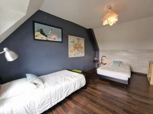 a bedroom with two beds and a blue wall at Cottage, Plougasnou in Plougasnou