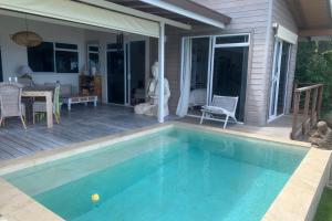 uma casa com uma piscina e um pátio em Villa WABISABI cosy home em Punaauia