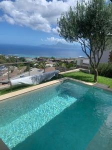 a swimming pool with a view of the ocean at Villa WABISABI cosy home in Punaauia