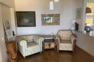 2 Stühle und ein Tisch im Wohnzimmer in der Unterkunft Villa WABISABI cosy home in Punaauia