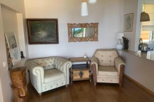 two chairs and a table in a living room at Villa WABISABI cosy home in Punaauia