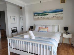 uma cama branca com almofadas num quarto em Citadel Suite em Port Macquarie