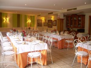 a banquet hall with white tables and white chairs at Hotel Cosgaya in Cosgaya