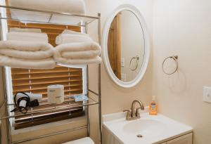 a bathroom with a sink and a mirror and towels at Log Cottages at Bryce Canyon #2 in Cannonville