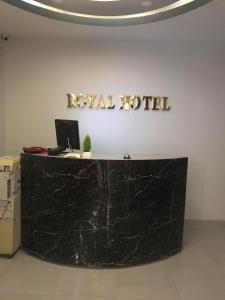 um balcão de mármore preto com um cartaz na parede em Royal Hotel em Qinā