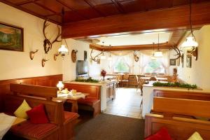 a restaurant with a dining room and a kitchen at Gasthof-Pension Berghof in Enzklösterle