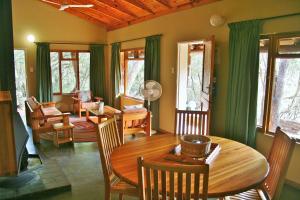 sala de estar con mesa de madera y sillas en Hlane Royal National Park, en Simunye