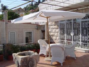 una mesa y sillas bajo una sombrilla en un patio en Apartments Ivory, en Dubrovnik