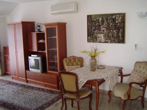 jadalnia ze stołem i krzesłami oraz telewizorem w obiekcie Apartments Ivory w Dubrowniku