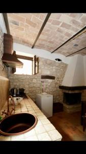 cocina con fregadero y chimenea. en Il Minotauro B&B a 5 minuti da Popoli, en Vittorito