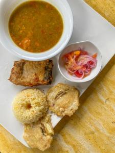a plate of food with a bowl of soup and biscuits at Chowa lodge in Nuquí