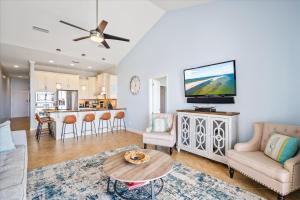 een woonkamer met een bank en een tv bij The Pelican Place - Amazing Views, Top Floor Condo in Dauphin Island